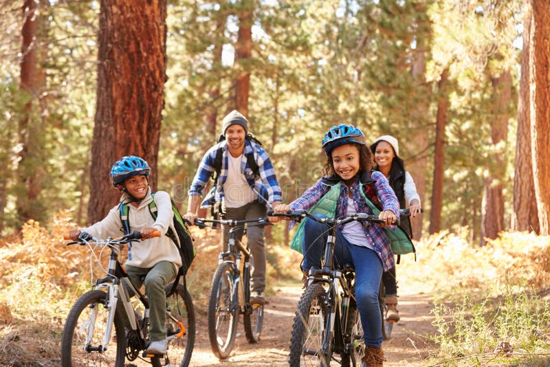 Famille d'afro-américain faisant un cycle par la région boisée d'automne image libre de droits