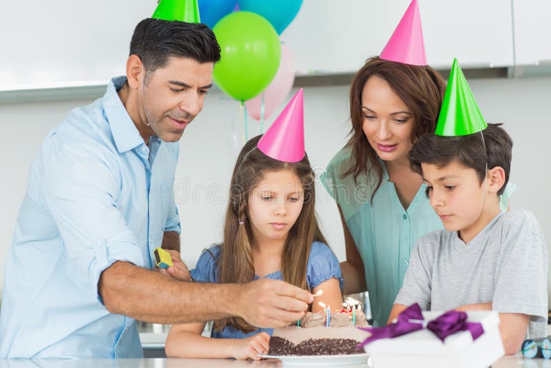 Famille de quatre avec le gâteau à une fête d'anniversaire photos libres de droits Famille de quatre avec le gâteau à une fête d'anniversaire photos libres de droits