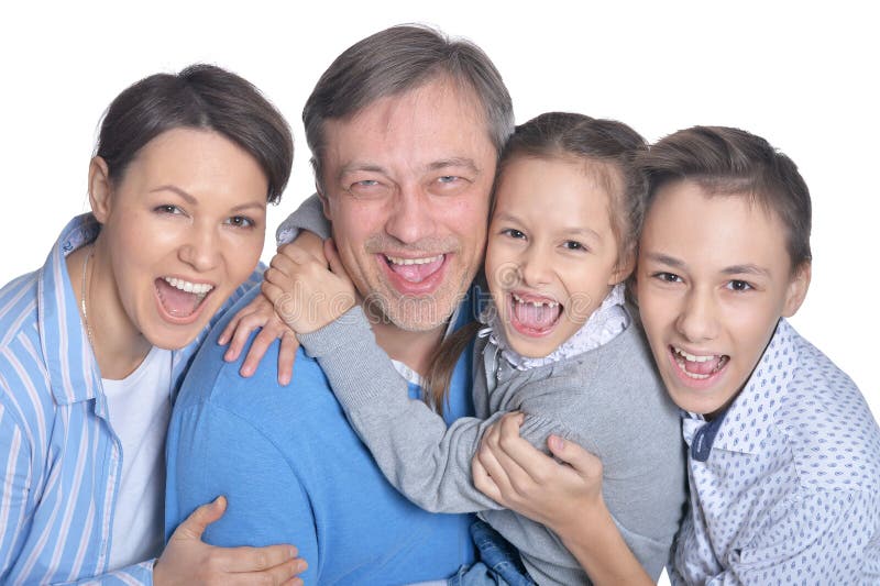 Famille de quatre de sourire heureuse posant sur le fond blanc photographie stock libre de droits Famille de quatre de sourire heureuse posant sur le fond blanc photographie stock libre de droits