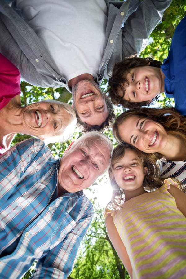 Smiling family with their heads in a circle in the garden. Smiling family with their heads in a circle in the garden