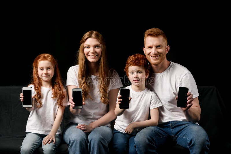 Famille de sourire montrant des smartphones photos libres de droits Famille de sourire montrant des smartphones photos libres de droits