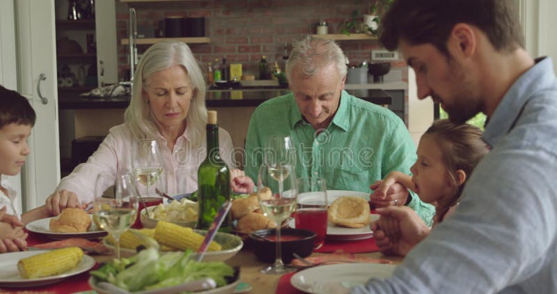Famille de trois générations qui mangent ensemble banque de vidéos