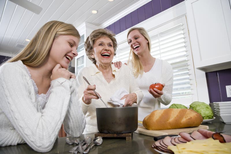 Famille de trois rétablissements dans la cuisine faisant cuire le déjeuner photo stock Famille de trois rétablissements dans la cuisine faisant cuire le déjeuner photo stock