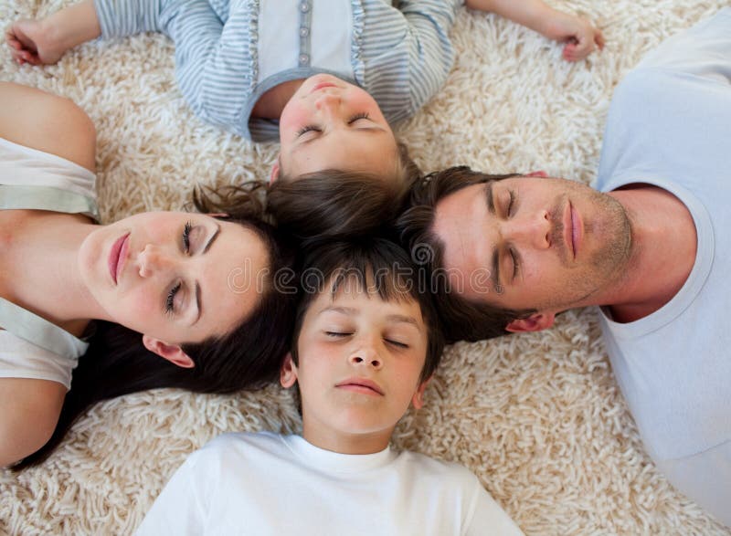 Young Family sleeping on the floor with heads together. Young Family sleeping on the floor with heads together