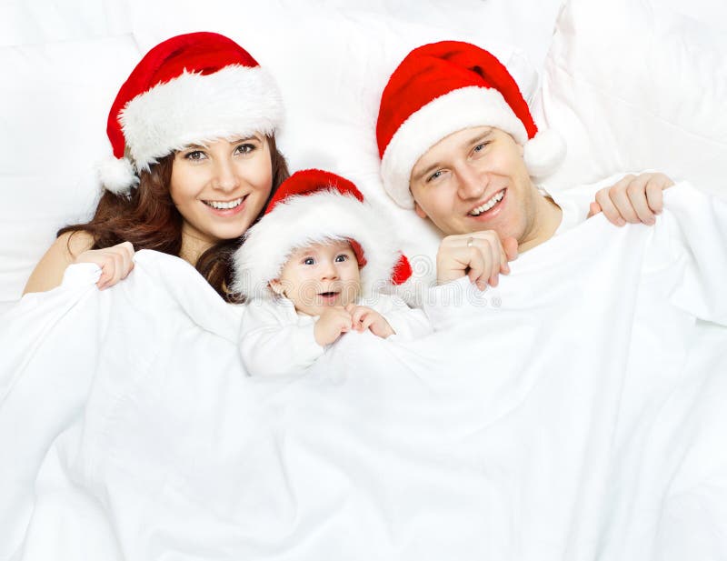 Famille et bébé de Noël dans le chapeau de Santa Claus au-dessus du blanc image libre de droits Famille et bébé de Noël dans le chapeau de Santa Claus au-dessus du blanc image libre de droits