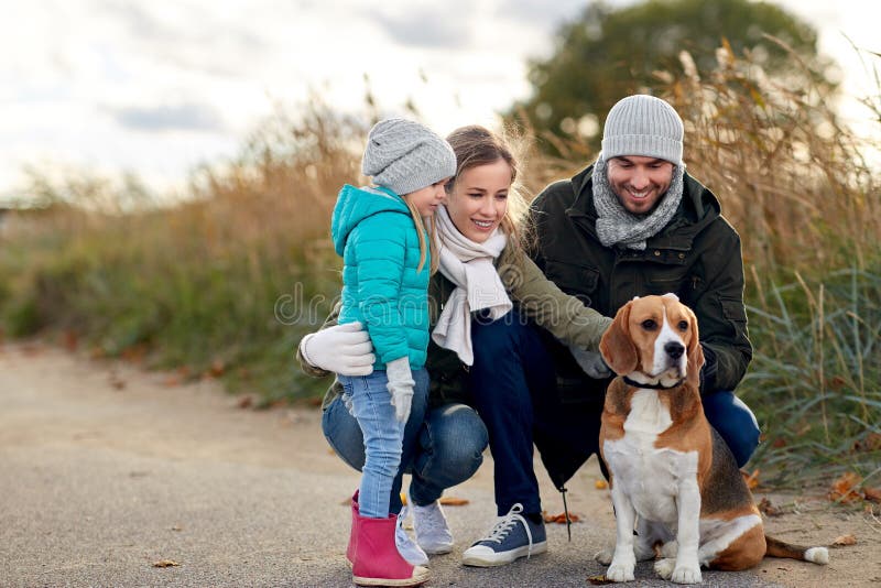 Famille heureuse avec le chien de briquet dehors en automne images stock Famille heureuse avec le chien de briquet dehors en automne images stock