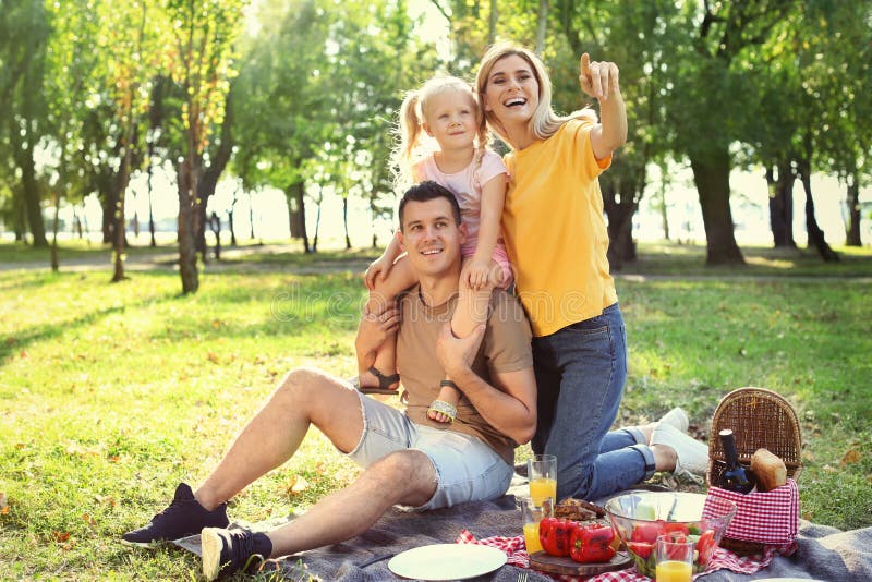 Famille heureuse ayant le pique-nique dans le parc image libre de droits Famille heureuse ayant le pique-nique dans le parc image libre de droits