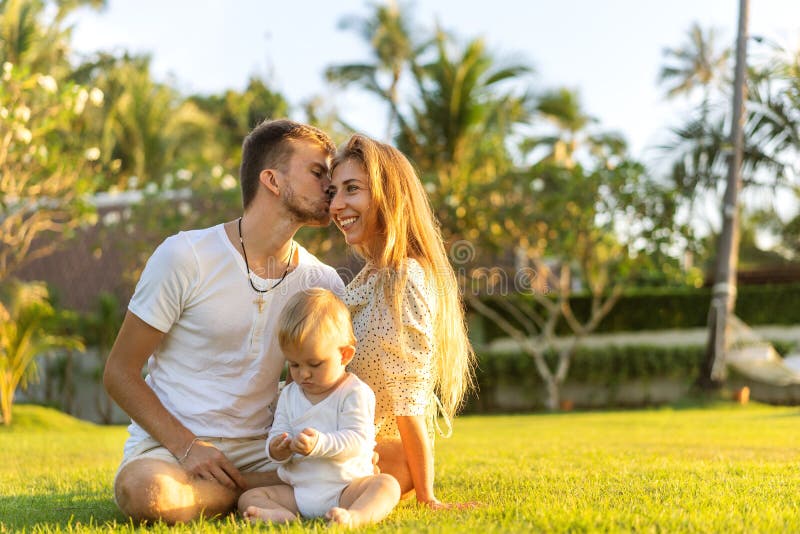 Famille heureuse sur l'île tropicale au coucher du soleil jouant avec le fils photographie stock Famille heureuse sur l'île tropicale au coucher du soleil jouant avec le fils photographie stock