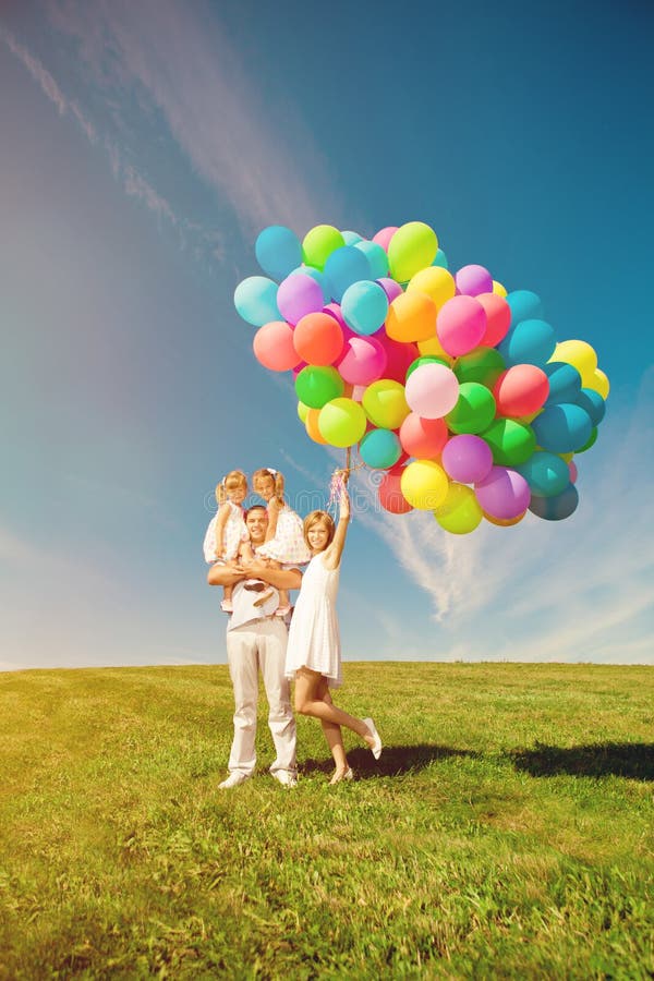 Famille heureuse tenant les ballons colorés Maman, ded et daughte deux