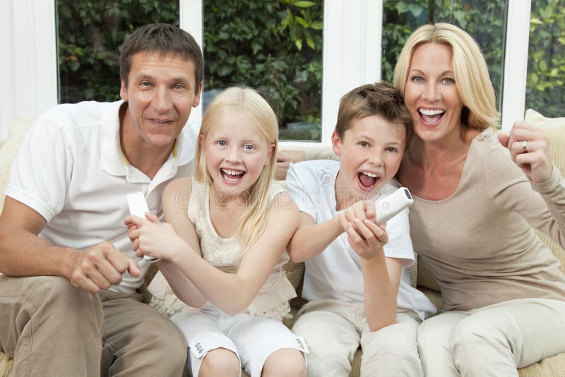 Famille heureux ayant l'amusement jouer des jeux vidéo photo stock Famille heureux ayant l'amusement jouer des jeux vidéo photo stock