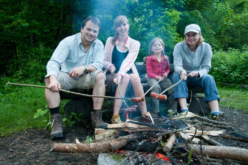 Famille heureux près de feu de camp photographie stock