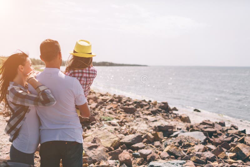 Famille heureux sur la plage Les gens ayant l'amusement des vacances d'été Père, mère et enfant contre la mer et le ciel bleus image libre de droits Famille heureux sur la plage Les gens ayant l'amusement des vacances d'été Père, mère et enfant contre la mer et le ciel bleus image libre de droits