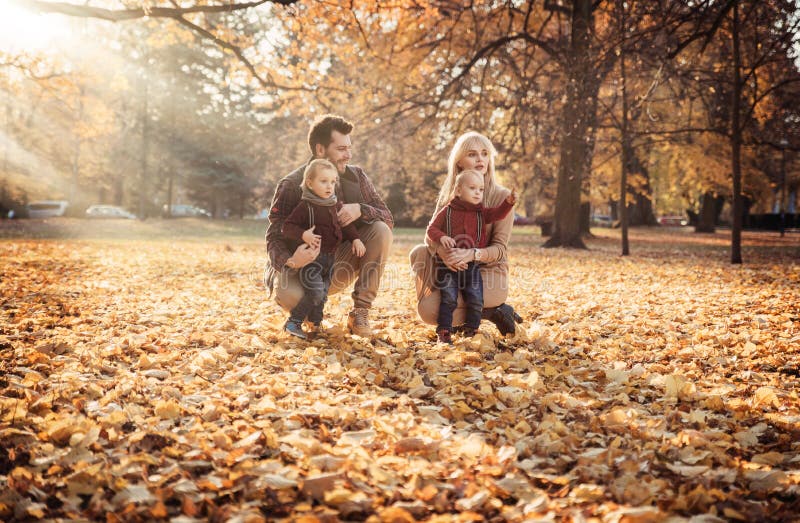 Famille joyeuse appréciant le temps splendide et automnal photo stock Famille joyeuse appréciant le temps splendide et automnal photo stock