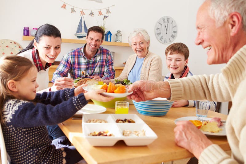 Famille multi de génération mangeant le déjeuner à la table de cuisine