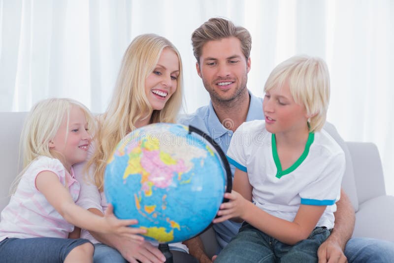 Famille regardant le globe ensemble photo stock