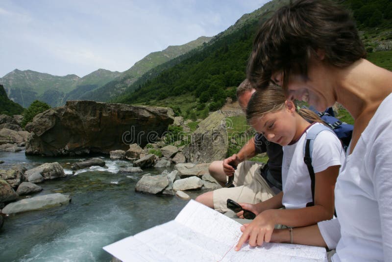 Famille regardant une carte par un fleuve photographie stock Famille regardant une carte par un fleuve photographie stock