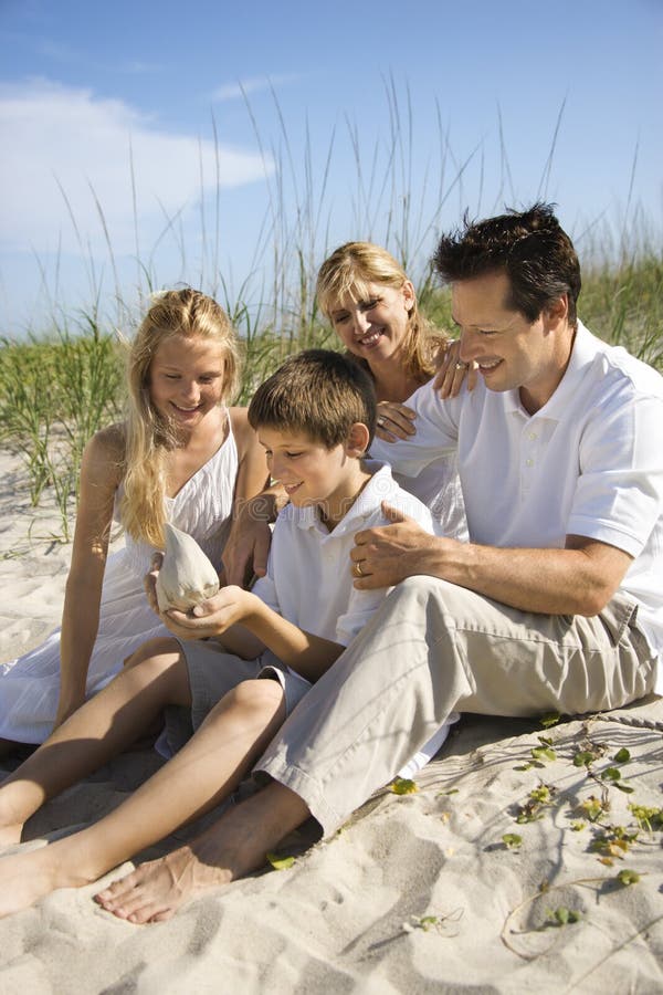 Famille s'asseyant sur la plage. images libres de droits