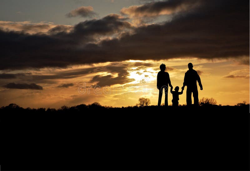 Famille en silhouette au coucher du soleil photographie stock libre de droits