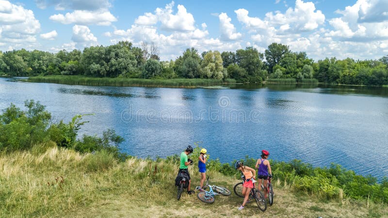 Famille sur des vélos faisant un cycle dehors, des parents et des enfants actifs sur les bicyclettes, vue aérienne de famille heu photo stock Famille sur des vélos faisant un cycle dehors, des parents et des enfants actifs sur les bicyclettes, vue aérienne de famille heu photo stock
