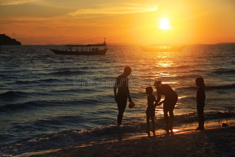 Famille sur la plage au coucher du soleil photo libre de droits Famille sur la plage au coucher du soleil photo libre de droits