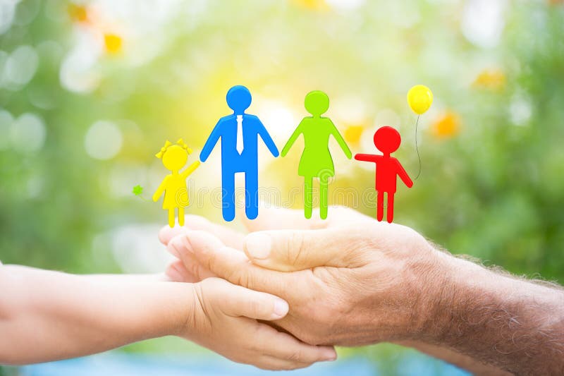 Child and senior men holding 3d family in hands against green spring background