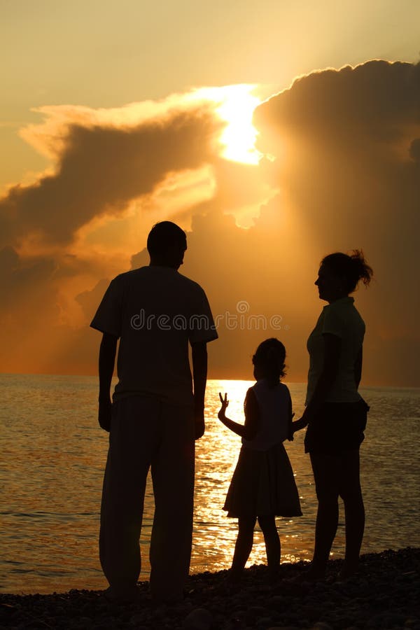 Family against glossing sea. Parents and daughter royalty free stock photos Family against glossing sea. Parents and daughter royalty free stock photos
