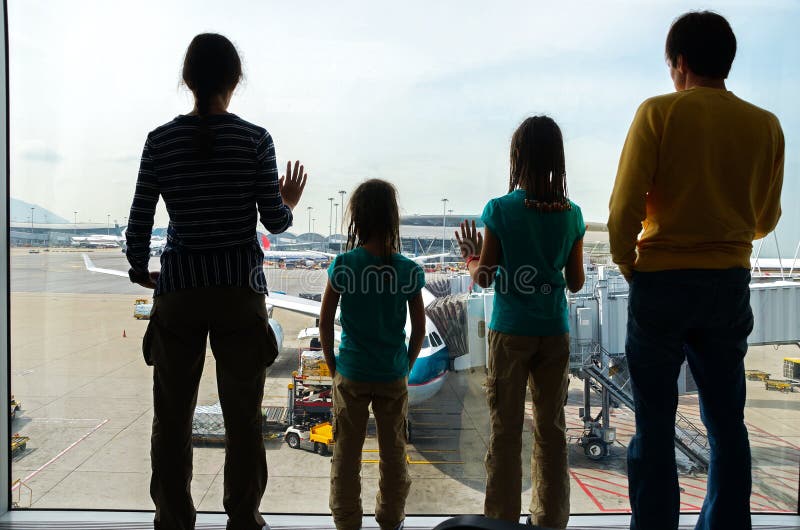 Family in airport, travel concept, silhouettes of parents with kids in terminal waiting for flight