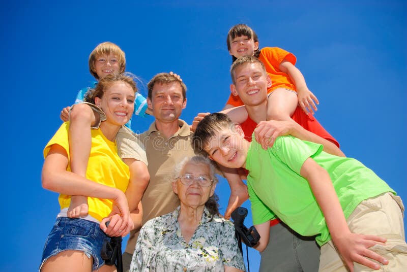 Familia común alrededor abuela sobre el soleado.