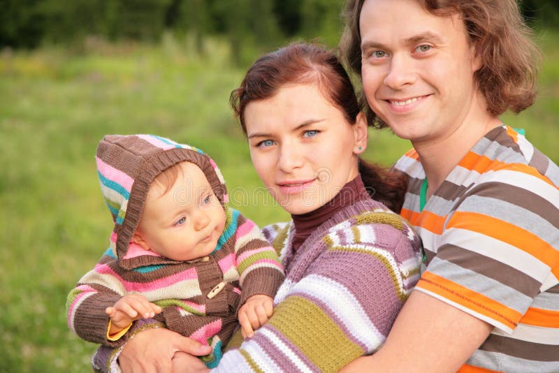 Family with baby in stripe clothes in park