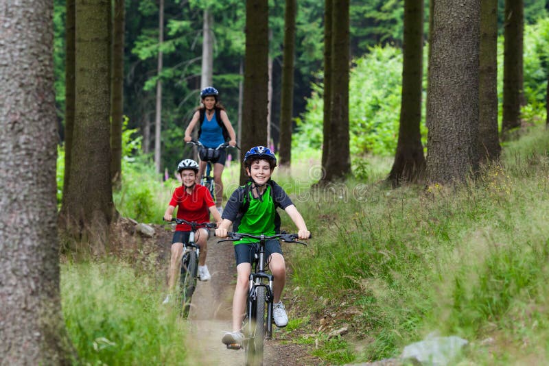 Mother and kids biking in forest. Mother and kids biking in forest