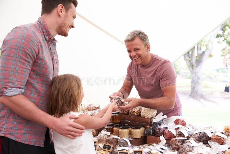 Family Buying Nuts From Stall At Farmers Market