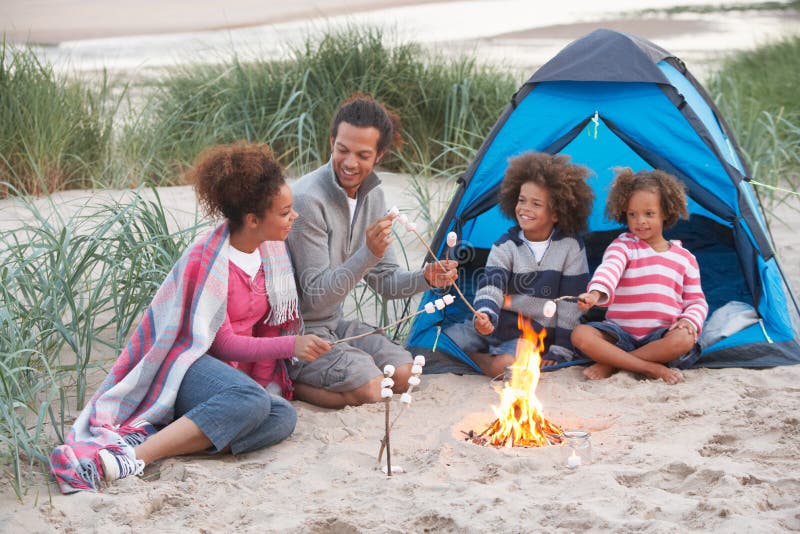 Family Camping On Beach And Toasting Marshmallows stock photos Family Camping On Beach And Toasting Marshmallows stock photos