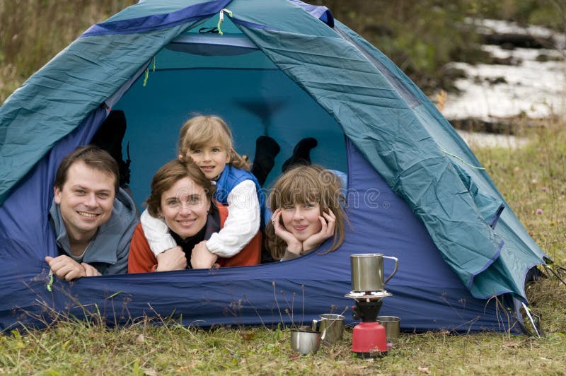 Familia feliz cámping en una carpa.