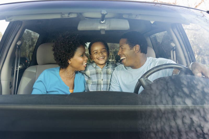 Cheerful African American family sitting in car. Cheerful African American family sitting in car