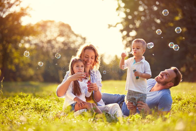 Family with children blow soap bubbles