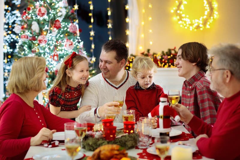 Family With Kids Having Christmas Dinner At Tree Stock Photo - Image of decoration, food: 130015182