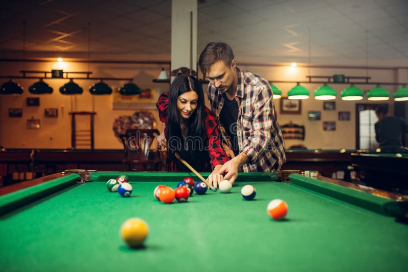 Family couple learn to play billiard, poolroom