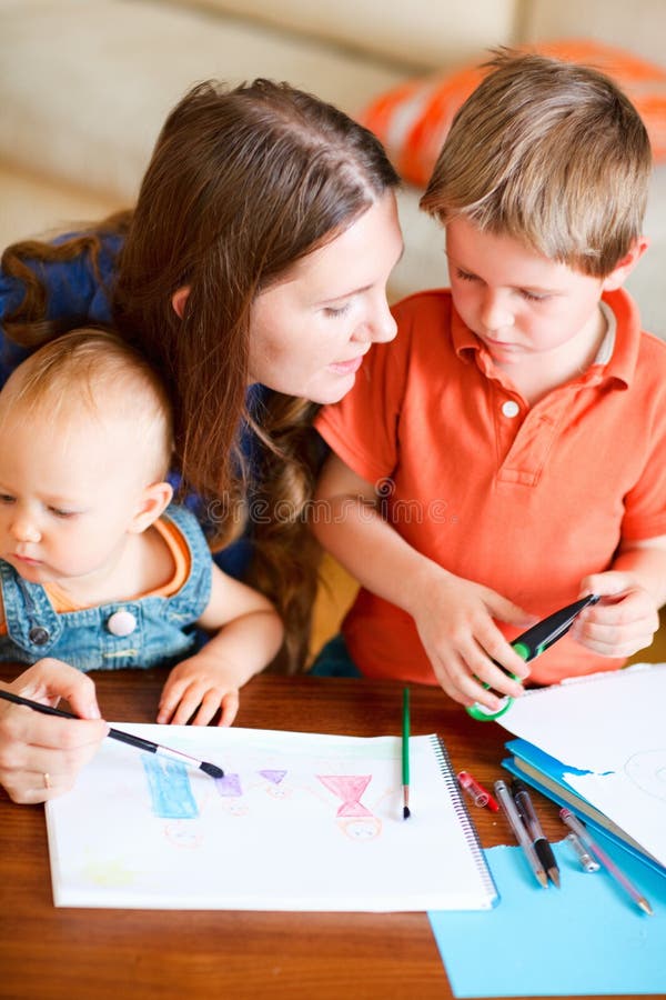 Young mother and her two kids drawing together. Can be used also in kindergarten/daycare context. Young mother and her two kids drawing together. Can be used also in kindergarten/daycare context.