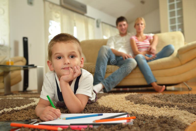 Happy young family teach leassons and prepare their son for school while draw on board at home. Happy young family teach leassons and prepare their son for school while draw on board at home