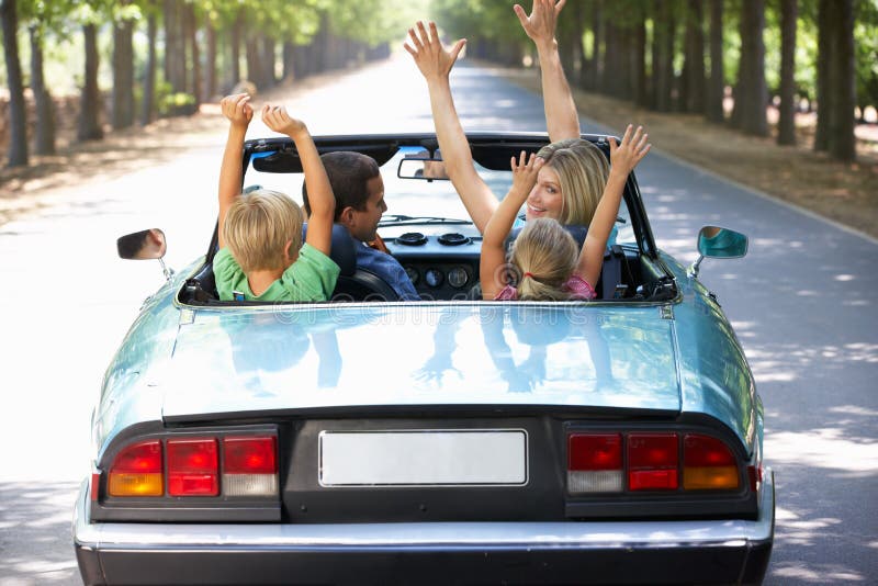 Family driving along in a sports car having fun