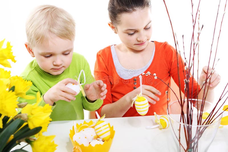 Family Easter- children decorates Easter eggs