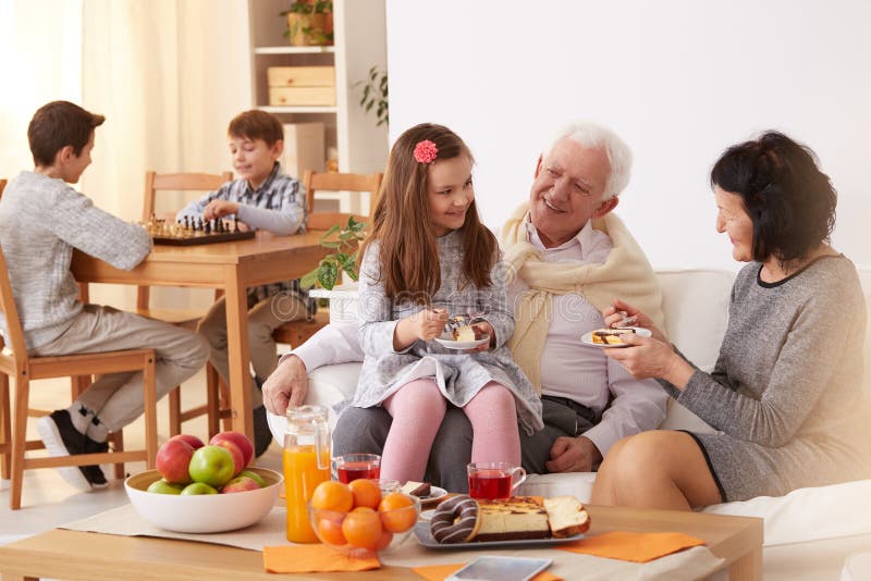 Family eating a cake. Happy family eating a cake in a living room royalty free stock photography