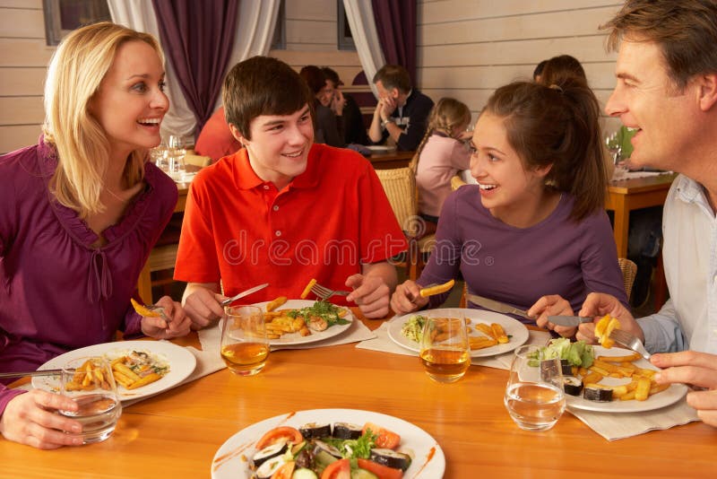 Familia comer almuerzo común en un restaurante sonriente entre cada próximo.