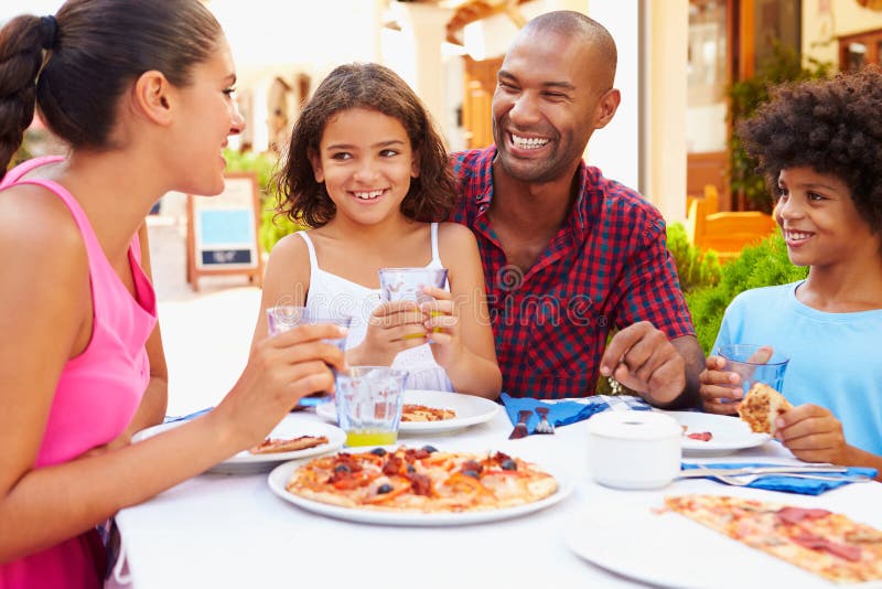 Family Eating Meal At Outdoor Restaurant Together