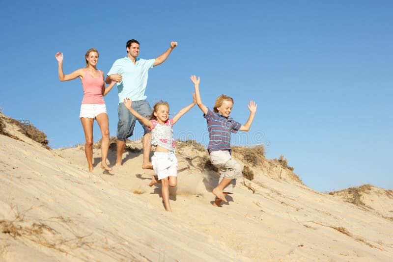 Family Enjoying Beach Holiday Running Down Dune