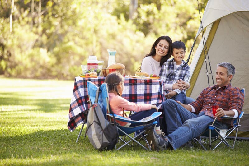 Family Enjoying Camping Holiday In Countryside Smiling