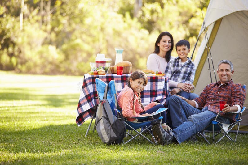 Family Enjoying Camping Holiday In Countryside Smiling To Camera