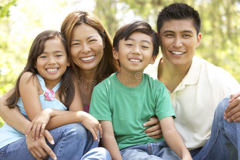 Asian Family Enjoying Day In Park Smiling Together