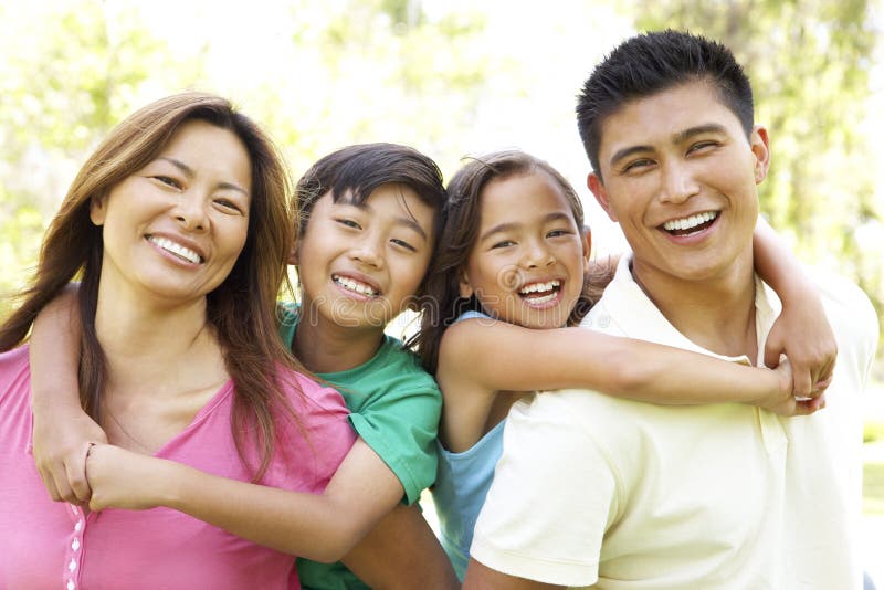 Asian Family Enjoying Day In Park Smiling