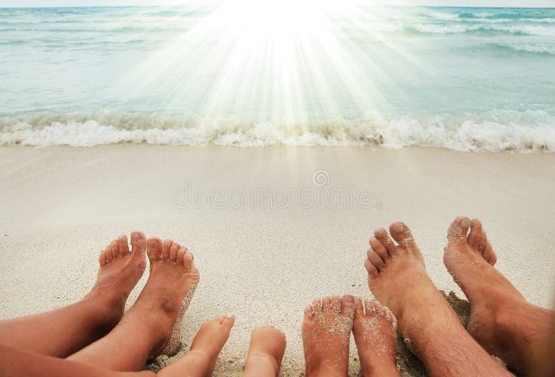 Family feet on the sand on the beach